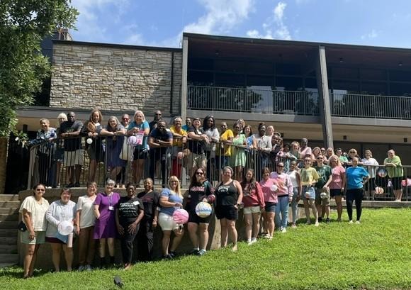 Group of educators posing for a picture in front of a building.